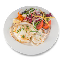 Plate of grilled cuttlefish with mixed salad with tomato, lettuce, carrot and heart of palm.