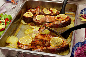 The salmon steak on the shoulder blade is removed from the baking tray.