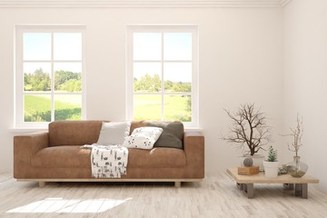 White living room with sofa and summer landscape in window. Scandinavian interior design. 3D illustration