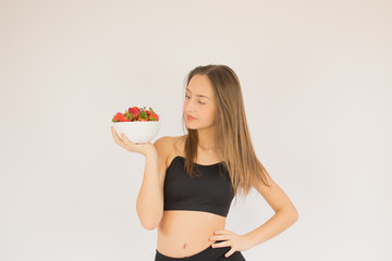 beautiful fitness girl with strawberries