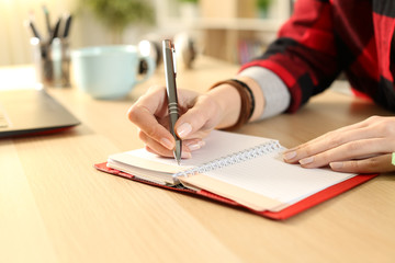 Student girl hands writing reminder on agenda