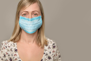 Closeup with a beautiful woman face wearing surgical mask.