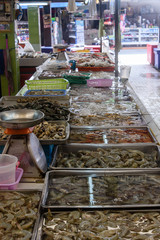 Seafood including prawns, shrimp, clams, sea snails, squid, octopus and green lipped mussels for sale at a Thai fishmonger food market stall, Thailand