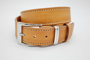 sample of brown leather men's belt with metal shiny handmade buckle, stitched on the edge, hand craft concept, white background,close up