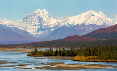 Two snow-capped mountains rise above the braided Susitna River