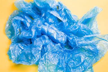 a lot of disposable blue shoe covers on a yellow background