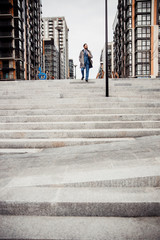 Man in a raincoat descending the staircase
