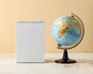  Globe with a sheet of paper for text. Minimalism, the concept of peace, education, travel, geography, ecology. 