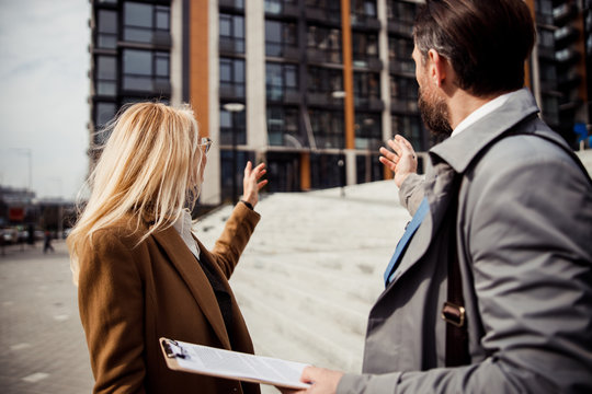 Broker with a clipboard standing next to his client