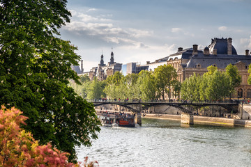 Paris in spring. View of the Louvre museum and the Bridge of Arts over Seine river. 