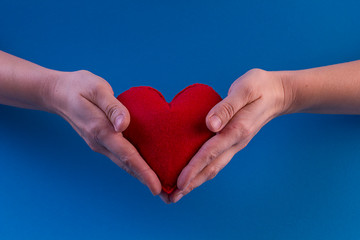 big red heart in hands on a blue background . medicine . Happy valentines day