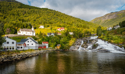 Fototapeta na wymiar Vista panorámica de cascada en típico pueblo noruego