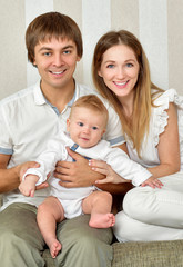 Young, happy family indoors. Family in the interior at home