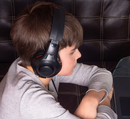 Boy in headphones spending time with notebook