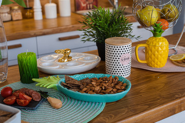 Picture of the big bright kitchen with white and brown cupboards with yellow pineapple tea kettle, white pepper mill and metal hanging with fruits and cookies