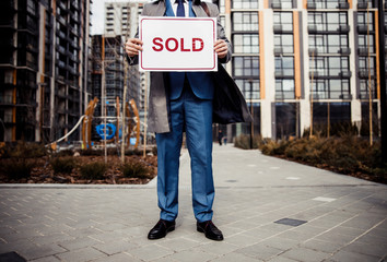 Broker standing in a new residential district