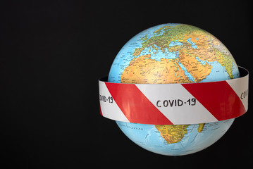 Planet earth with caution barrier tapes. Fight and prevention against coronavirus. Global quarantine concept. In the foreground Europe, Africa, Asia. Black background