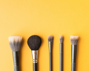  Professional makeup brushes top view on a yellow background with place for text. Skin care. Flatlay.