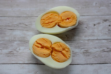 two halves of a boiled egg isolated on a wooden background