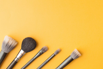  Professional makeup brushes top view on a yellow background with place for text. Skin care. Flatlay.