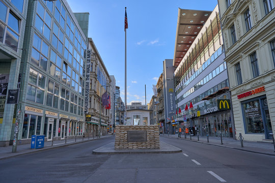 berlin, germany, 05.04.2021: deserted streets at us check point charlie with view of the historical buildings and the berlin wall museum in the background