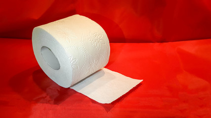 White toilet paper roll isolated on red background. Soft hygienic paper. Panic and phobia  concept caused by pandemic