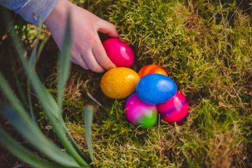 Kinderhand greift nach Ostereier in einem Nest