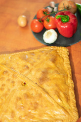 Galician empanada surrounded by other products on the table