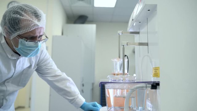 professional doctor laboratory worker watching equipment testing drug dissolution spbas . quality control on factory. pharmaceutical plant. concept automated, pills production