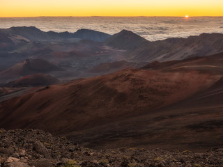 Fototapeta na wymiar Sun just peaking over the clouds at the top of Maui in Haleakela National Park.