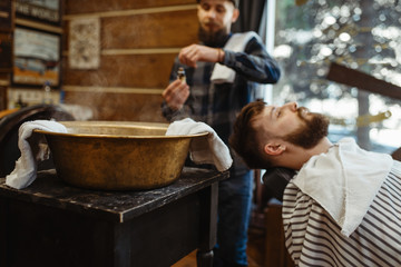 Barber soaks the towel, beard cutting, barbershop