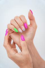 Lots of color gloss manicure hands has different blotches in pink background.