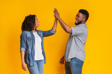 Common Success. Happy african american couple giving high-five, greetng each other