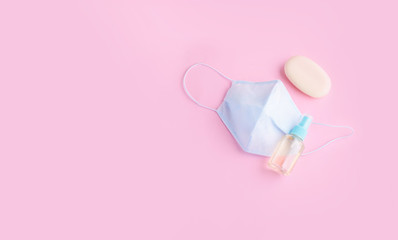 Blue face mask with soap and hand antiseptic on a light background. Protection from the virus.