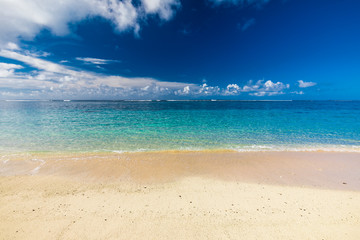 Tropical beach on south side of Samoa Island with coconut palm trees