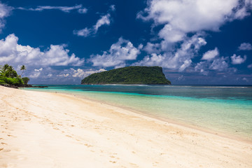 Tropical beach on south side of Samoa Island with coconut palm trees