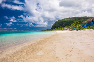 Tropical beach on south side of Samoa Island with coconut palm trees