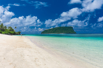 Tropical beach on south side of Samoa Island with coconut palm trees