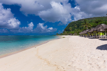 Tropical beach on south side of Samoa Island with coconut palm trees
