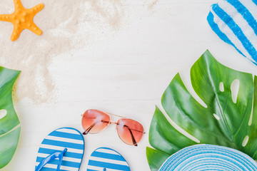 Flat lay composition with a summer hat and flip flops on a light background