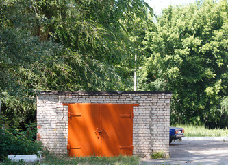 a lonely garage in the woods with a new gate