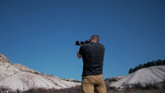 Brutal photographer with a beard takes a picture of a huge canyon 
