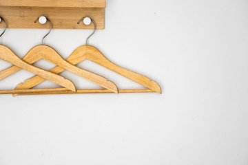 Clothes wooden hangers on a white wall.