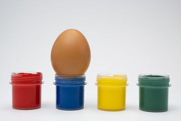 chicken eggs in colored cups on a white background