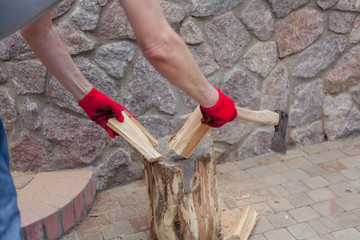 Hands chop log on stump closeup