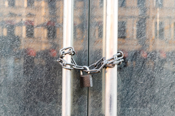 Lockdown shop market closed due to coronavirus pandemic door locked with chain. Bankruptcy of a...