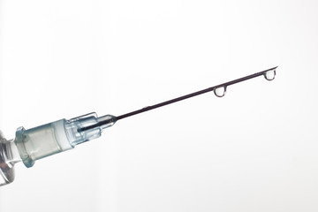 syringe with a needle and drops on a bright background 