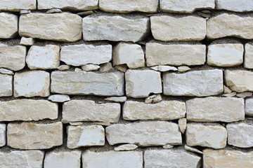 Close up and texture of a bright stone wall with joints