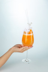 Close up of a hand holding a glass of Singapore cocktail on white background with copy space.