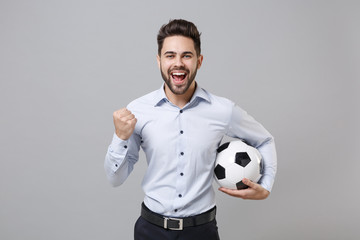 Happy young business man football fan in light shirt isolated on grey background. Achievement...